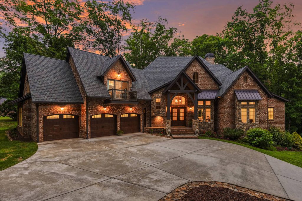 Virtual twilight exterior of a luxury brick home with warm lights