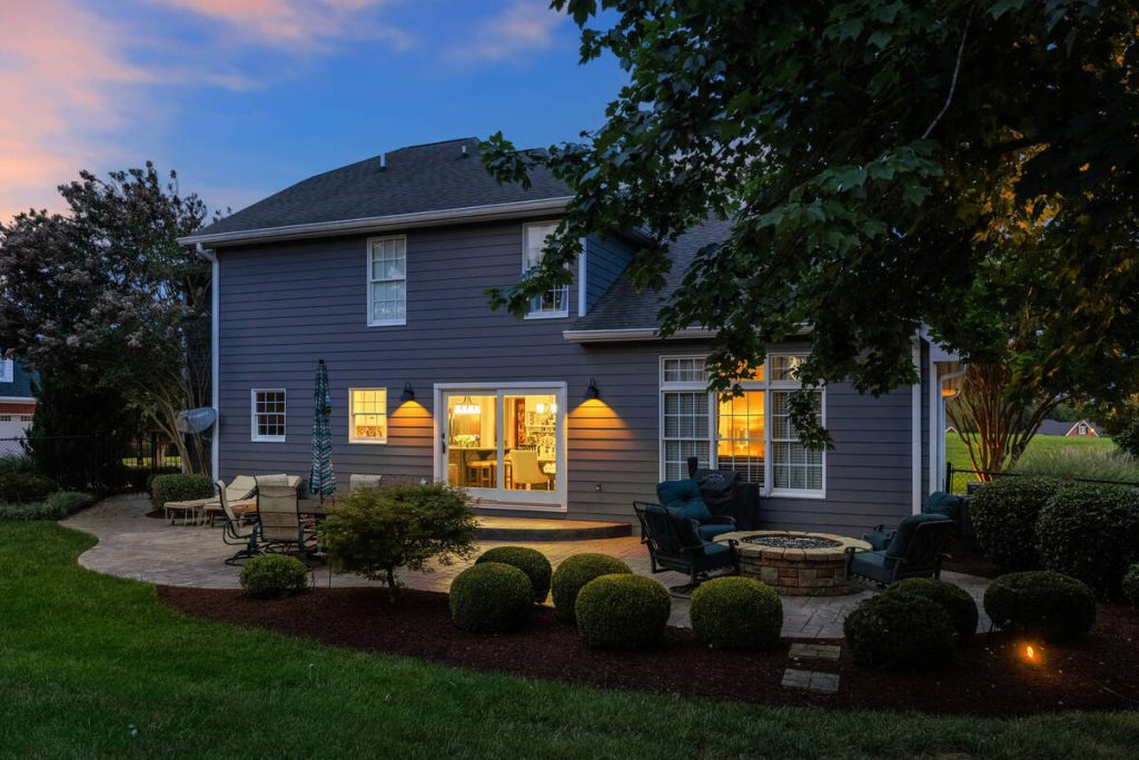 Virtual twilight backyard view with warm exterior and interior lighting