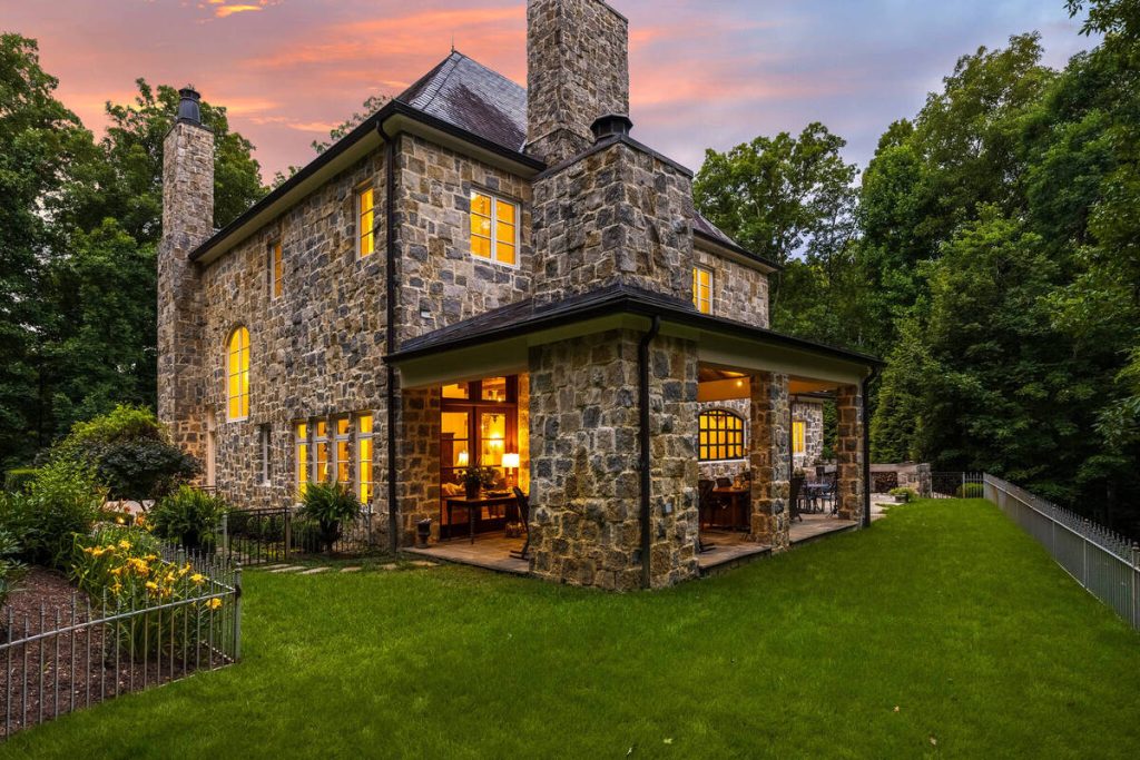 Virtual twilight photo of a stone home with warm window lighting